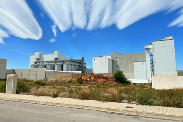 Obraz premium Grain storage. Silo at Agricultural farm. Wheat flour production in Spain, Almenara. Elevator for corn storage. Feed Silos Hopper for wheat storage and barley. Wheat flour plant. Agriculture industry