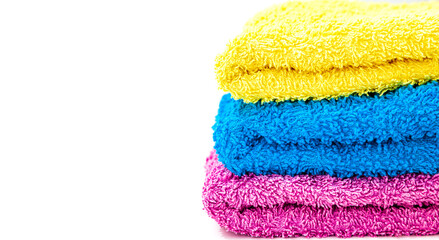Three towels of different color over white background
