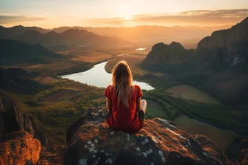 Tuinposter photo of a person sitting on a rock meditating on a beautiful mountain landscape © Pedro