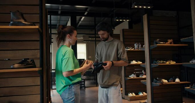 Man Businessman and woman in green t-shirt shoe designer communicate about new shoe collection at shoe factory. Business communication in the Loft style office