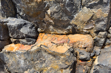 Granite Stone background, rock texture. Wall stone Granite background. Rock with cracks and layers. Rough rocky texture of mountains. Mining and geology. Texture of marble wall.