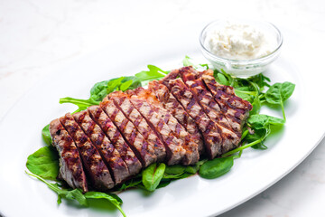beef steak with garlic dip and spinach and ruccola leaves
