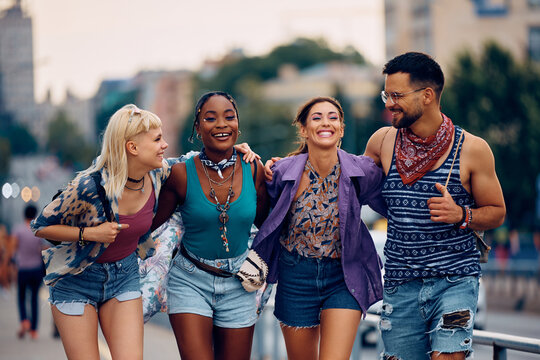 Multiracial group of happy friends have fun while going to summer music concert.