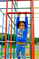 Fototapeta premium beautiful young black African boy with dreadlocks playing in a park .