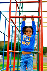 Fototapeta premium beautiful young black African boy with dreadlocks playing in a park .