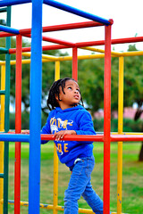 Obraz premium beautiful young black African boy with dreadlocks playing in a park .