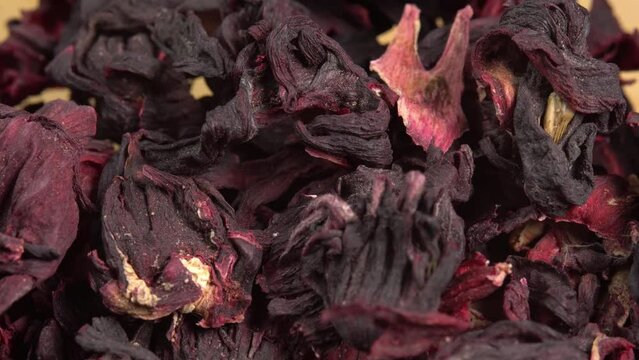 Hibiscus tea leaves rotate as background. Dried hibiscus leaves for brewing tea. Rose tea karkade with sour taste. Red hibiscus flowers. Herbal background
