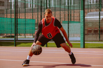 Fototapeta premium A basketball player plays streetball on a hot day.