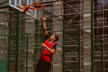 A basketball player plays streetball on a hot day.