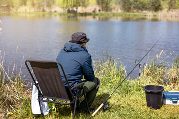 Fototapeta na wymiar fishing rod on lake water background. Man catching fish by spinning on lakeside