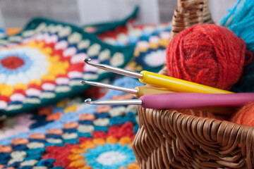Colored hooks in a basket with threads for knitting