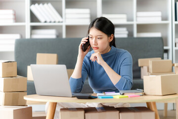 Young business owner woman prepare parcel box and standing check online orders for deliver to customer on tablet, laptop Shopping Online concept.