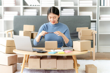 Portrait of Starting small businesses SME owners female entrepreneurs working on receipt box and check online orders to prepare to pack the boxes, sell to customers, SME business ideas online.