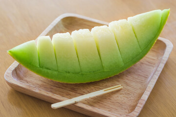 green melon on wooden dish