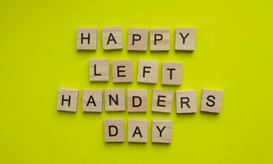 August 13, International Day of Lefties, Lefthanders Day, minimalist banner with the inscription in wooden letters on a yellow background