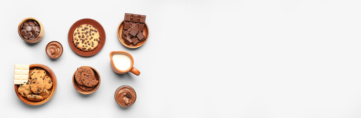 Different tasty cookies with chocolate and jug of milk on light background with space for text