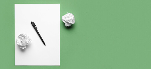Blank sheet with crumpled paper and pen on green background with space for text