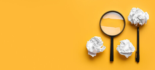 Crumpled paper sheets with magnifier and pen on yellow background with space for text