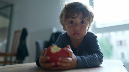 Child taking a bite of apple fruit kid eats healthy snack