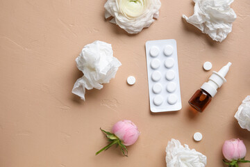 Nasal drops with pills, flowers and tissues on beige background. Seasonal allergy concept