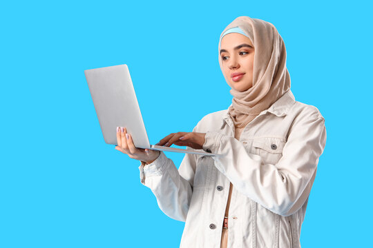 Arabian female programmer with laptop on blue background