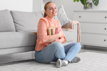 Happy young woman with books at home