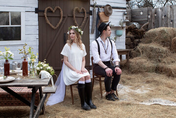 country bride in a white short dress and groom in a white shirt in the village wedding, boho style.