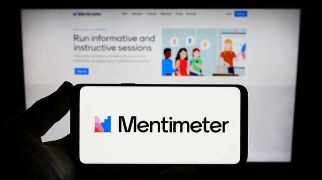 Stuttgart, Germany - 07-09-2023: Person holding smartphone with logo of presentation software company Mentimeter on screen in front of website. Focus on phone display.