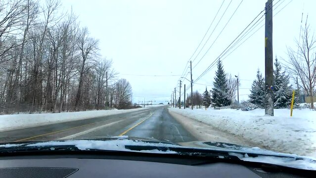 Driving through the snowy streets through the residential area during the winter, driver's POV, timewarp, 4K