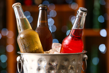 Bucket with bottles of cold beer in bar, closeup