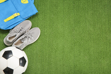 Sneakers with backpack and soccer ball on color background - Powered by Adobe