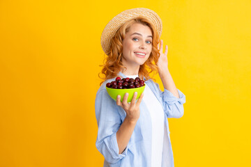 Portrait of beauty redhed woman with cherries on yellow isolated background.