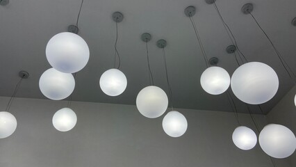 round electric chandeliers on a gray ceiling