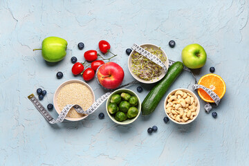 Composition with healthy food and measuring tape on blue grunge background. Diet concept