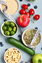 Composition with healthy food and measuring tape on blue grunge background. Diet concept