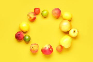 Frame made of different fresh fruits on yellow background
