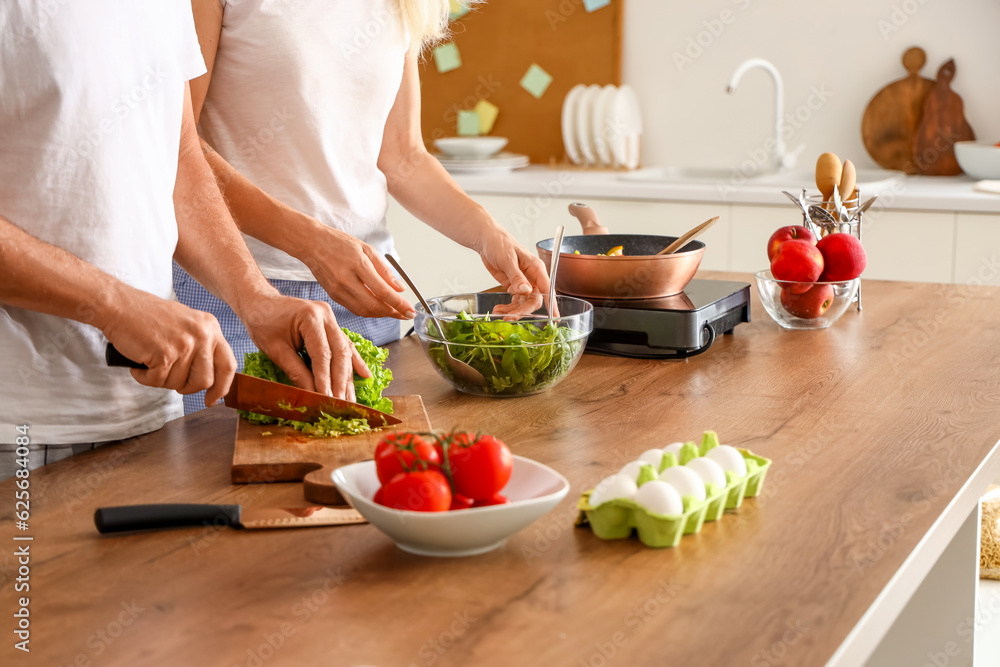 Wall mural Mature couple cooking in kitchen, closeup