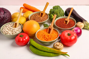 Different fresh vegetables and cereals on white background