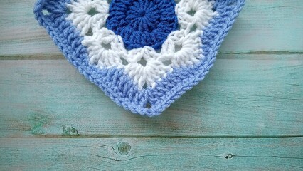 Fototapeta premium Blue, white crochet elements and orchid. Crochet texture, place for an inscription, adapted for mobile phone