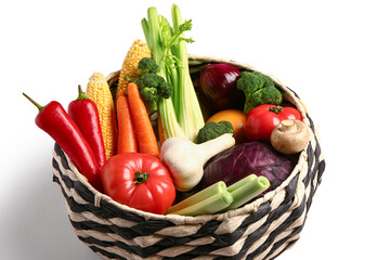 Wicker bowl with different fresh vegetables on white background