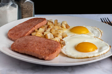 fried eggs  with fried spam and hash browns,