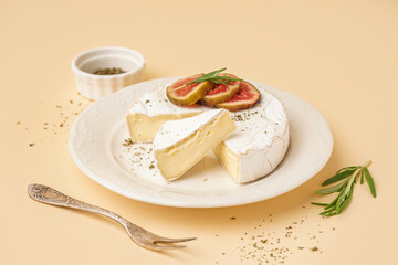 Plate with pieces of tasty Camembert cheese on yellow background