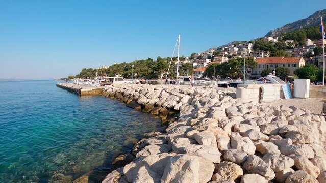 The ship sails from the pier in the port of the Adriatic Sea in the village of Brela Croatia.Yacht cruise on the Croatian Adriatic Sea. The resort village of Brela on the Adriatic coast of Croatia