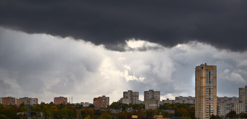 A dark rain cloud descends on a sunny city