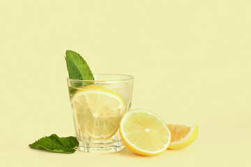 Glass of tasty mojito and lemon on color background