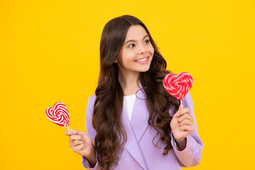 Hipster teenager child girl lick lollypop. Sugar nutrition, candy and sweets. Child eat lollipop popsicle. Happy teenager, positive and smiling emotions of teen girl.