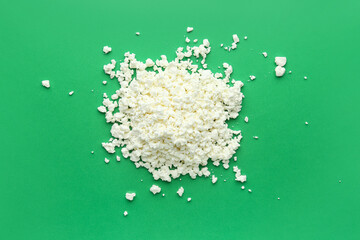 Heap of tasty cottage cheese on green background