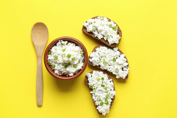 Tasty sandwiches with cottage cheese on yellow background