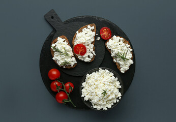 Tasty sandwiches with cottage cheese and tomatoes on black background