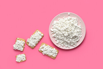 Tasty crackers with cottage cheese on pink background